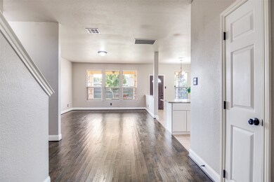 Unfurnished living room featuring a textured wall, dark wood-style floors, a textured ceiling, and a chandelier