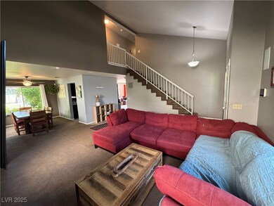 Carpeted living room with high vaulted ceiling. Vi