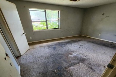 Carpeted spare room featuring baseboards