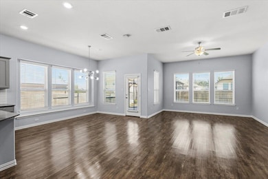 Unfurnished living room featuring dark wood-style floors, a chandelier, ceiling fan, and recessed lighting