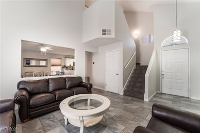 Living room featuring a towering ceiling, baseboar