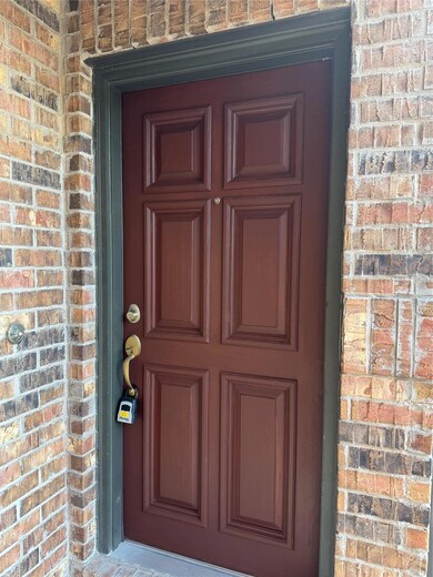Property entrance featuring brick siding