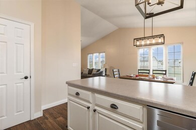 Kitchen featuring white cabinets, medium oak  hardwood / wood-style flooring, decorative light fixtures, and lofted ceiling