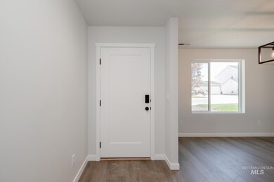 Doorway to outside with wood finished floors and baseboards