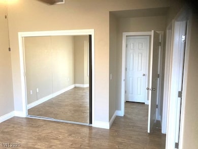 Unfurnished bedroom with wood finished floors, bas
