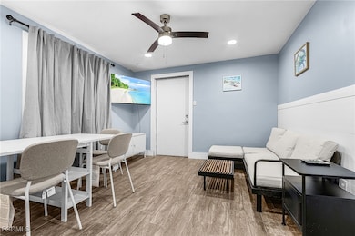 Home office featuring light wood finished floors, ceiling fan, and recessed lighting