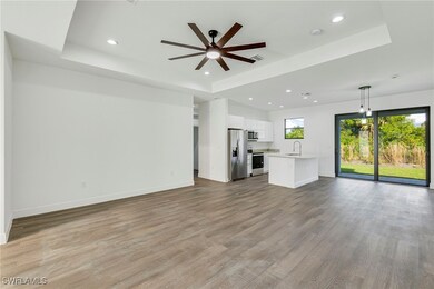 Unfurnished living room featuring sink, light hard