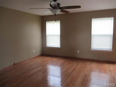Spare room with wood finished floors and a ceiling fan