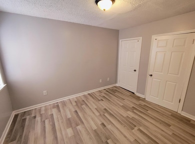Unfurnished bedroom featuring a textured ceiling and light wood-style floors