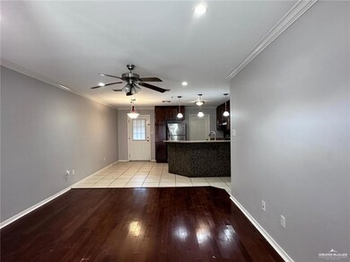 Unfurnished living room with sink, ornamental molding, light tile patterned floors, and ceiling fan