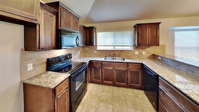 Kitchen with black appliances, a sink, lofted ceil