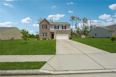 Traditional home with concrete driveway, a front lawn, board and batten siding, and a garage