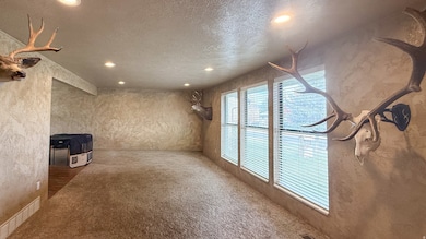 Unfurnished living room featuring recessed lighting, carpet, and a textured ceiling