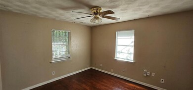 Unfurnished room featuring ceiling fan and hardwoo