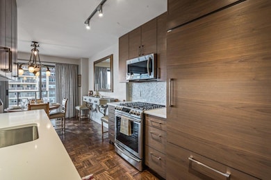 Kitchen with an inviting chandelier, a sink, decorative backsplash, light countertops, and stainless steel appliances