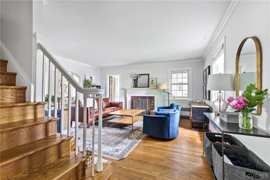 Living room featuring crown molding, radiator, wood-type flooring, and a fireplace