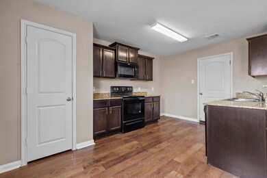 Kitchen with visible vents, a sink, dark brown ca