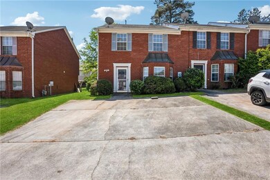 View of property featuring a front lawn and brick 