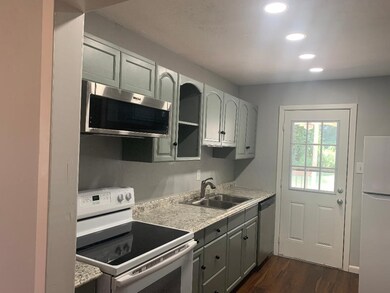 Kitchen with stainless steel appliances, dark wood-type flooring, recessed lighting, and gray cabinets
