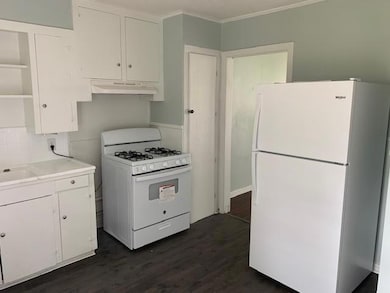 Kitchen featuring ornamental molding, white applia
