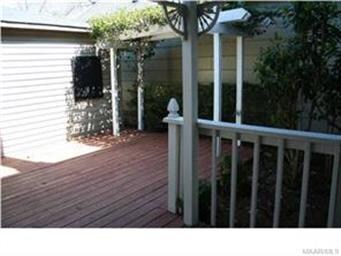 Custom built wooden deck enclosed by a wooded priv
