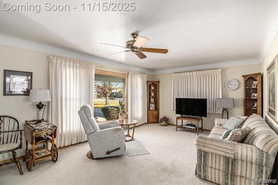 Carpeted living room featuring a ceiling fan