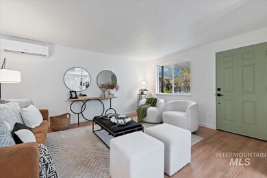 Living room featuring wood finished floors, a wall mounted air conditioner, and a textured ceiling