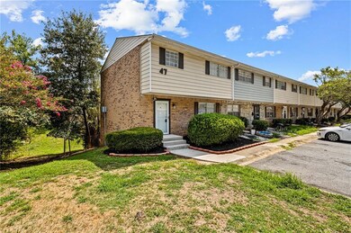 Colonial-style house featuring brick siding and a front lawn