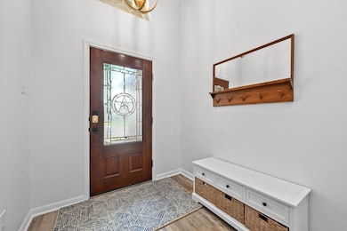 Foyer featuring light wood finished floors and baseboards