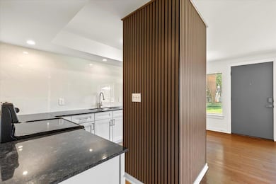 Indoor wet bar featuring light wood-style floors,