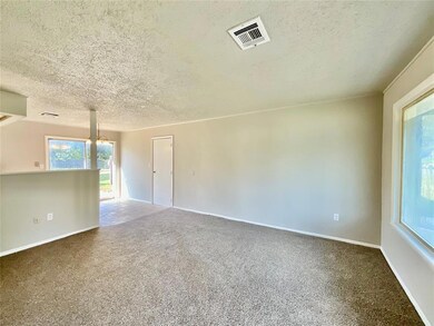 Carpeted spare room featuring a notable chandelier