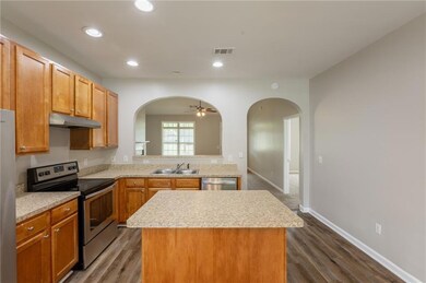 Kitchen featuring a kitchen island, arched walkway