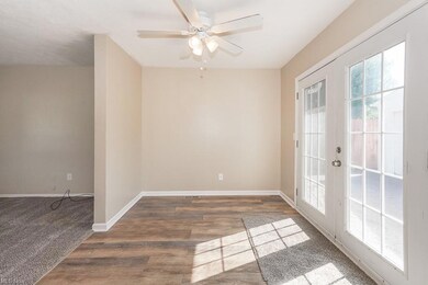 Carpeted empty room with ceiling fan and french do
