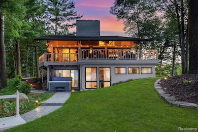 Back of property at dusk featuring a hot tub & extensive hardscaping