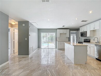Kitchen featuring white cabinets, a center island,