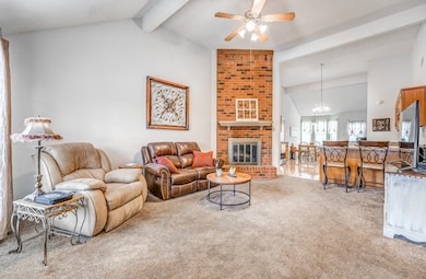 Living room with carpet flooring, a ceiling fan, a