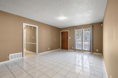 Unfurnished room featuring light tile patterned f