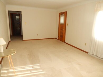 Living room with neutral carpet and walls. This ma