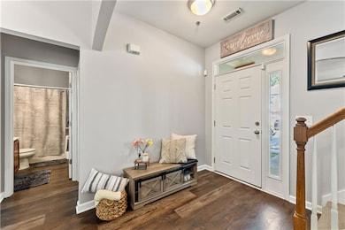 Entrance foyer featuring dark wood-style flooring and stairs