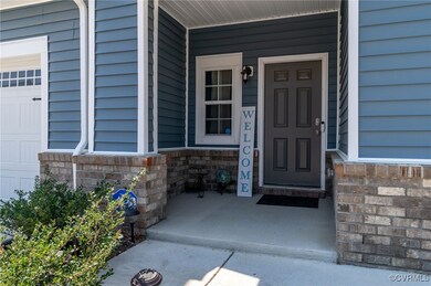 Property entrance featuring covered porch and ston