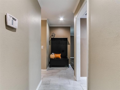 Hall with a textured wall, crown molding, and recessed lighting