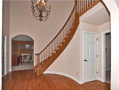 front entryway with dramatic curved stairway, hard