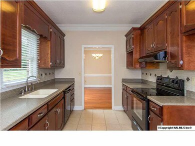 The remodeled kitchen has been treated to a seamless, solid-surface countertop and sink combination and refinished cabinetry.