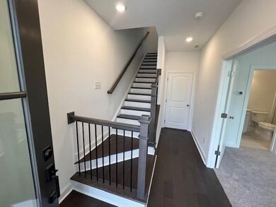 Stairway with wood finished floors and recessed lighting