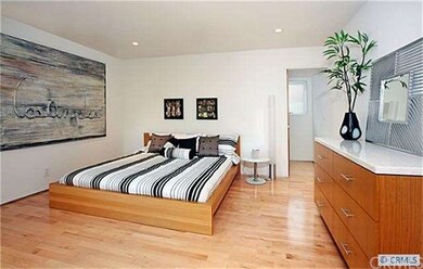 The downstairs guest bedroom has warm wood floorin