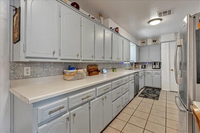 Living area featuring a chandelier, dark wood-type flooring, baseboards, and crown molding
