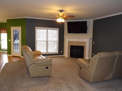 Great room with carpet, ceiling fan, recessed lighting & gas fireplace.