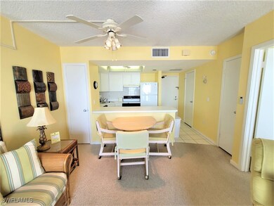 Dining space featuring a textured ceiling, ceiling fan, light colored carpet, and light tile patterned floors
