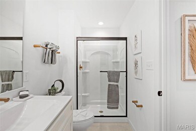 Bathroom featuring tile patterned flooring, vanity, toilet, and walk in shower