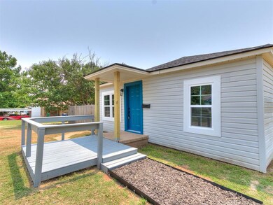 Back of property with a wooden deck and a lawn